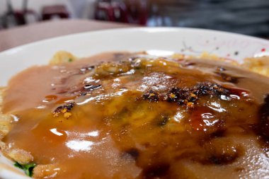 Kadınlar geleneksel Tayvan usulü istiridye omleti yerler.