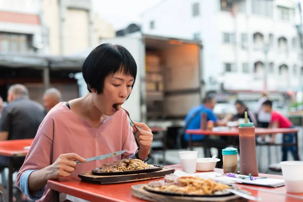 大人の女性は通りで台湾のナイトマーケットステーキを食べる — ストック写真