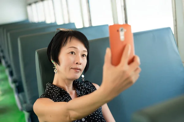Olgun Asyalı Kadın Tren Vagonunda Selfie Çekiyor — Stok fotoğraf