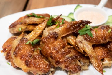 Tabakta kahverengi renkte kızarmış tavuk kanadı