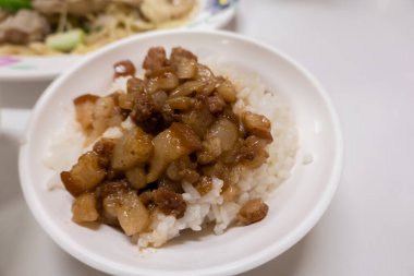 closeup image of braised pork on rice on table