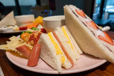 Çilekli sandviç ve sıcak çorba ile ahşap üzerinde kahvaltı