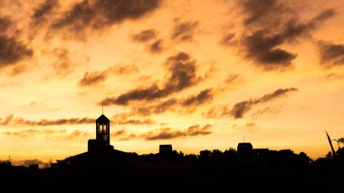 Şehrin siluet kulesinin üzerinde dramatik bulutlarla gün batımı manzarası