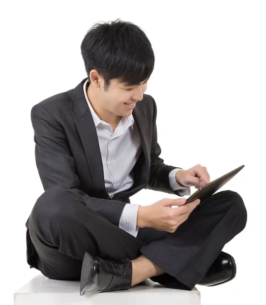 Asian business man using pad and sit on ground — Stock Photo, Image