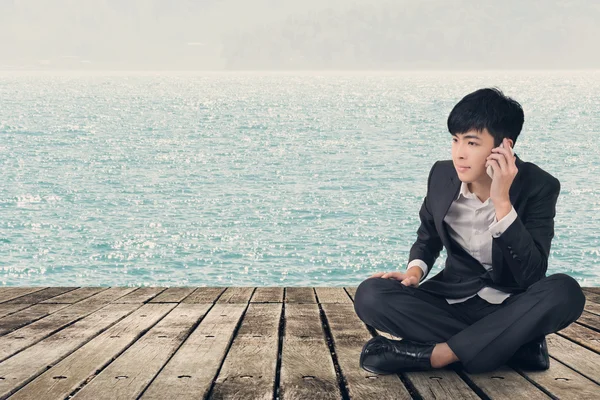 Asian business man take a call and sit on ground — Stock Photo, Image