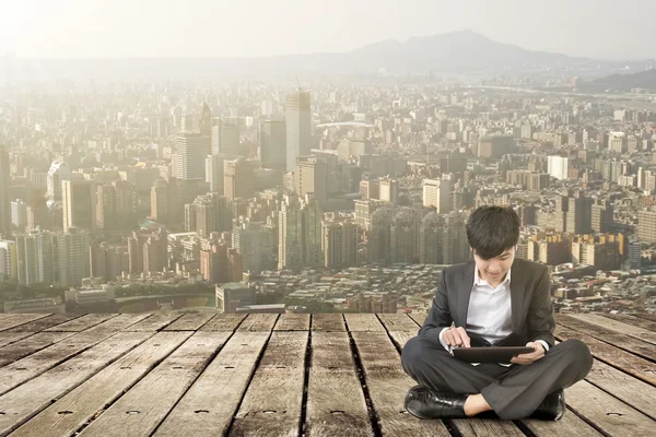 Asian business man using pad and sit on ground — Stock Photo, Image