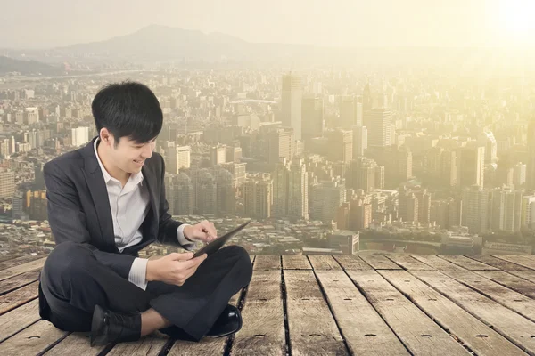 Asian business man using pad and sit on ground — Stock Photo, Image