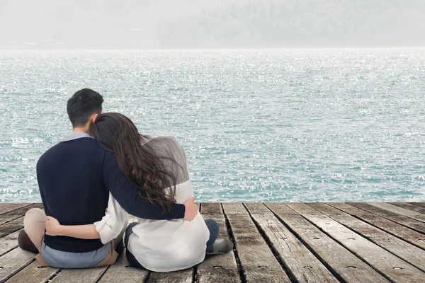 Asian young couple sit and hug together — Stock Photo, Image