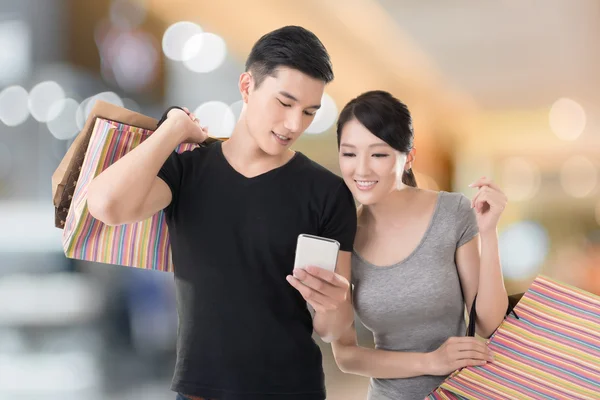 Compras y mirando el teléfono celular — Foto de Stock