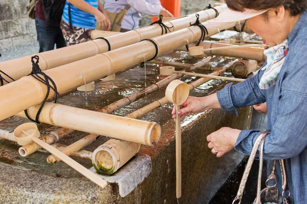 Návštěvníci si ruce s japonským vody naběračky — Stock fotografie