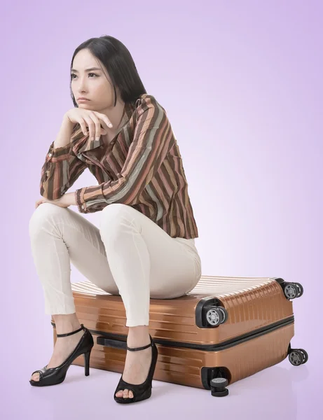Azji kobieta myśli i siedzi na bagaż — Zdjęcie stockowe