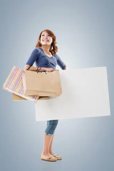 Winkelen vrouw bedrijf tassen en leeg bord — Stockfoto