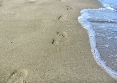 Kum plaj, dalga ve ayak izleri