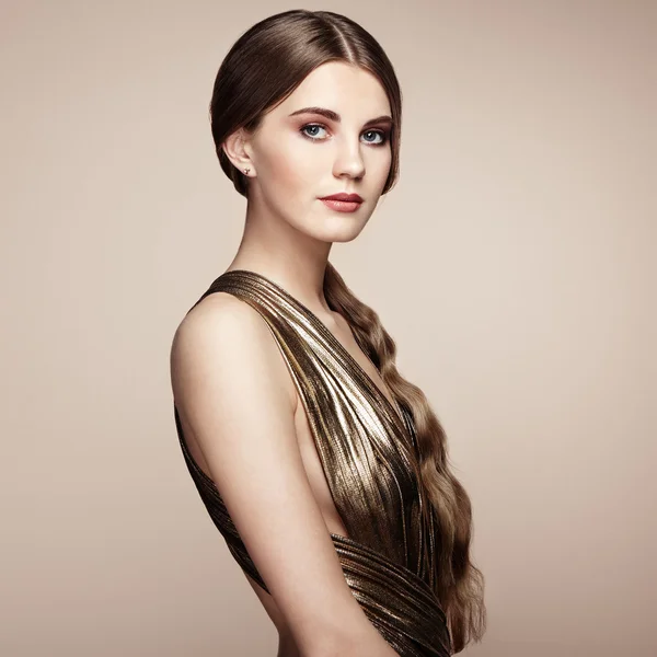 Fashion portrait of young beautiful woman in gold dress — Stock Photo, Image