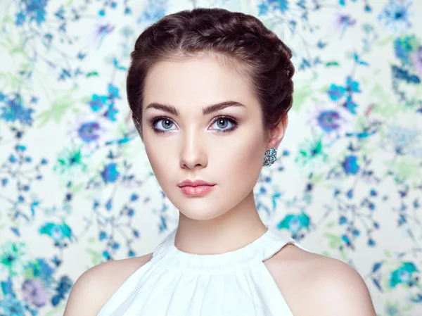 Retrato de una joven hermosa mujer sobre un fondo de flores — Foto de Stock