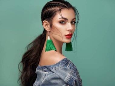 Mükemmel makyajlı esmer kız. Kıvırcık saçlı güzel bir model kadın. Bakım ve güzellik ürünleri. Saçları örgülü bir kadın. Mücevherleri olan bir model. Turkuaz arkaplan