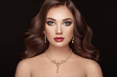 Uzun ve parlak kıvırcık saçlı esmer kız. Kıvırcık saçlı güzel model kadın. Bakım ve Güzellik Ürünleri. Mükemmel Makyaj ve Mücevher