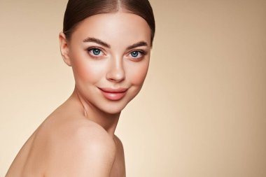 Temiz tenli güzel bir genç kadın portresi. Sağlıklı ciltli bir model, yakın portre. Kozmetik, güzellik ve kaplıca