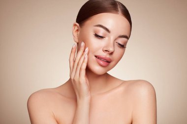 Temiz tenli güzel bir genç kadın portresi. Sağlıklı ciltli bir model, yakın portre. Kozmetik, güzellik ve kaplıca