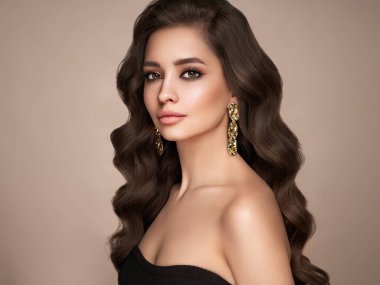 Mükemmel makyajlı esmer kız. Uzun kıvırcık saçlı, gülümseyen güzel model kadın. Bakım ve güzellik saç ürünleri.