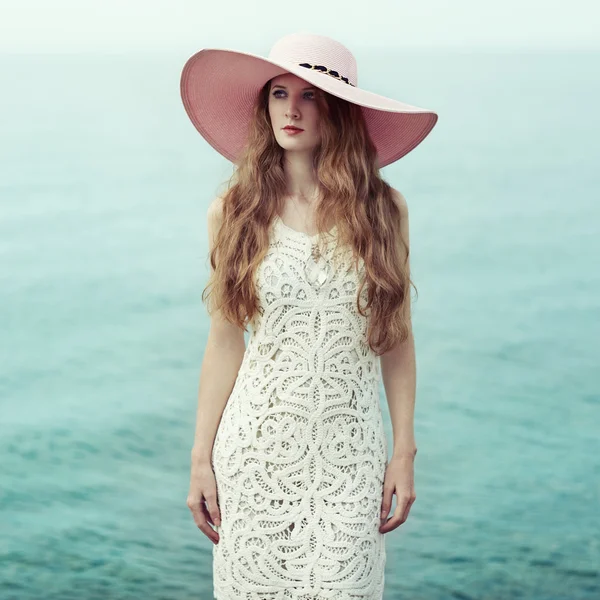 Beautiful woman in hat on the sea — Stok fotoğraf