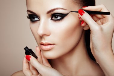 Makeup artist applies eye shadow clipart