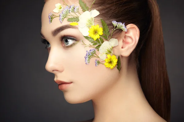 Gesicht der schönen Frau mit Blumen verziert — Stockfoto