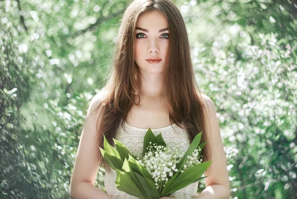 Portrait of beautiful young woman with lily of the valley — Stock Photo, Image