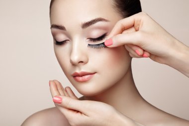Makeup artist glues eyelashes clipart