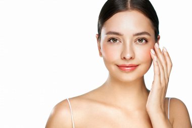 Cilt bakımı. Güzel yüzlü kadın sağlıklı yüz portresine dokunuyor. Doğal makyajlı güzel bir manken beyaz arka planda parlayan nemli cilde dokunuyor.