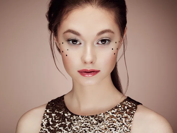 Retrato de una hermosa joven con un vestido dorado brillante —  Fotos de Stock