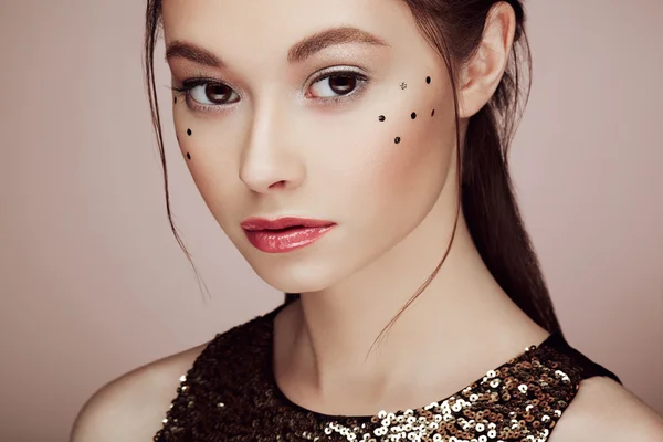 Portrait of beautiful young woman in a shiny golden dress — Stock Photo, Image