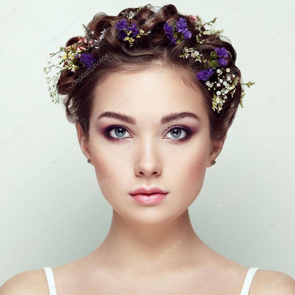 Face of beautiful woman decorated with flowers