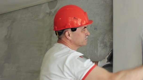 Specialist aligns the wall in the room. Repairs in the living room — Stock Footage Specialist Aligns Wall Room Repairs Living Room Royalty Free Stock Footage