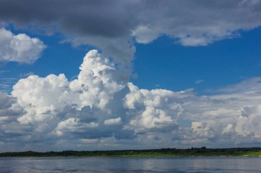 Yazın ortasında büyük bir nehrin yatağının üzerinde güçlü bulutlar.