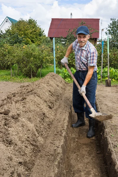 Agricultor cavando a terra para construir uma cama profunda de — Fotografia de Stock