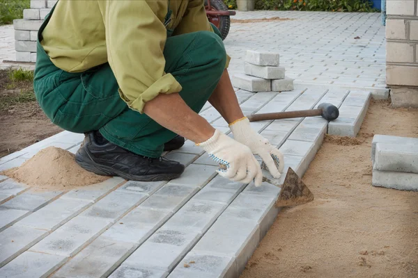 Dělník staví bloky na chodníku — Stock fotografie