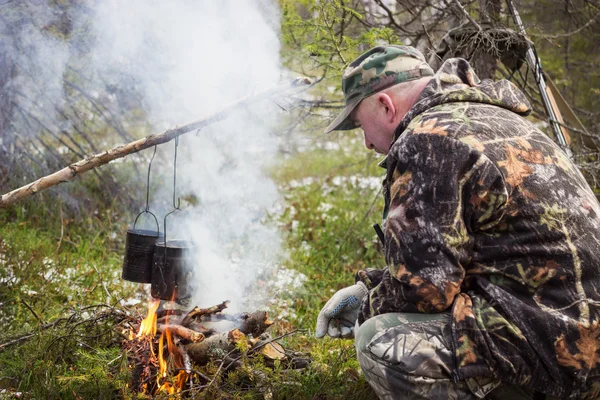 Huntsman bylo vaření nad táborák — Stock fotografie