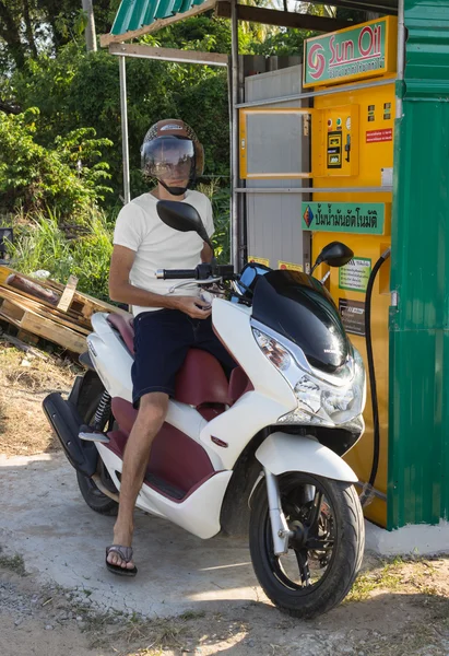 Driver of scooter buys gasoline at gas station village — Stock Photo, Image