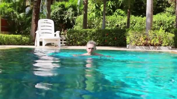 Зрілий чоловік плаває в басейні — стокове відео