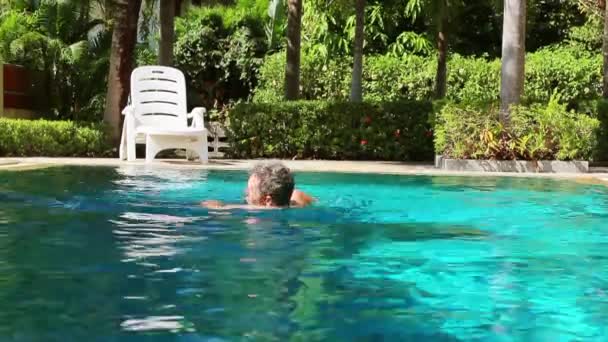 Idős ember úszás medencében — Stock videók