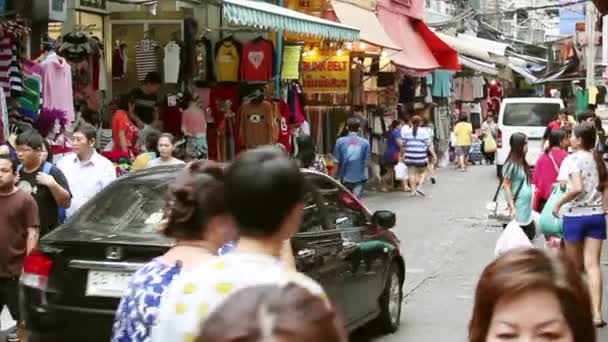 Menschen gehen zwischen den Ständen in einer engen Straße — Stockvideo