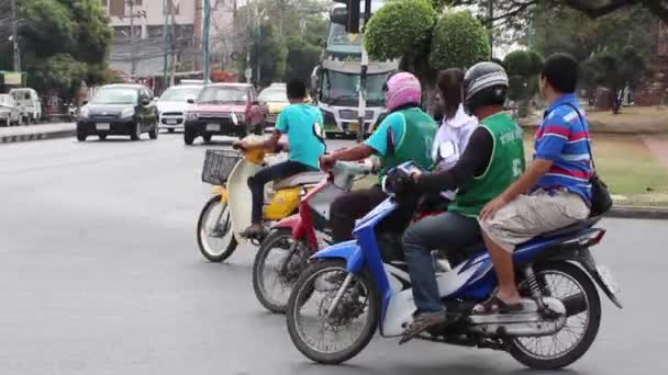 Люди на мотороллере едут по городу в Таиланде — стоковое видео