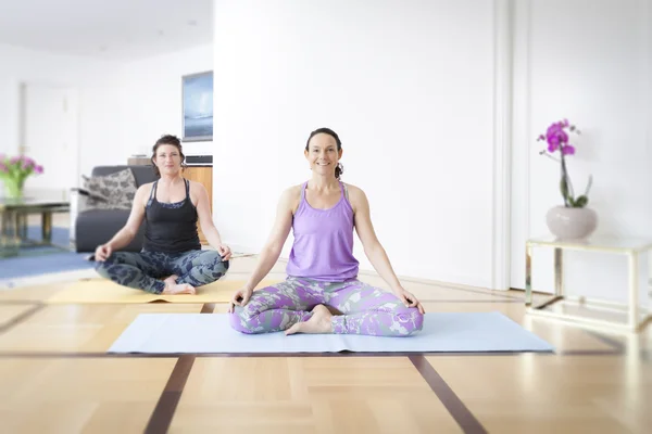 Dos mujeres haciendo yoga — Foto de Stock