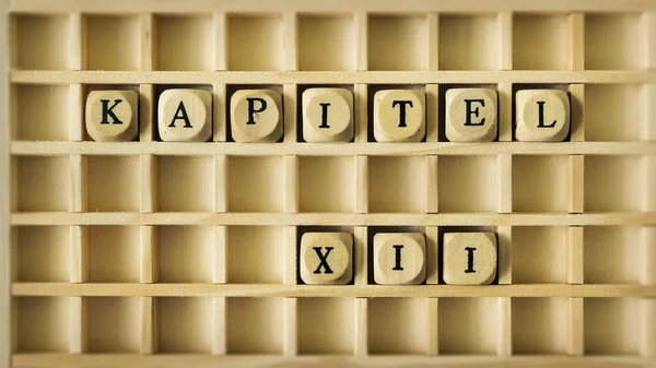 Kapitel tolv skriven i tyska scrabble — Stockfoto