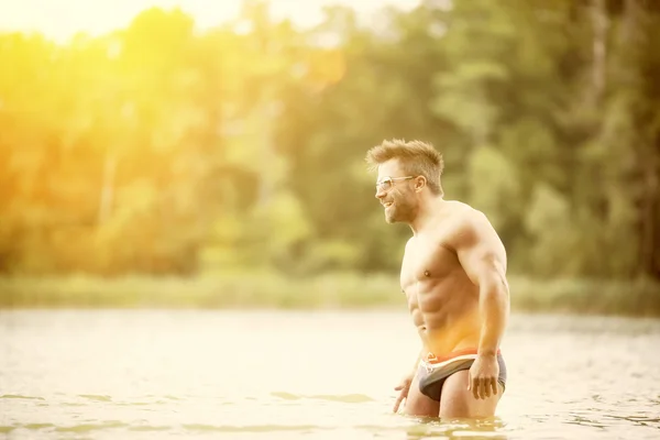 Homem musculoso no lago — Fotografia de Stock