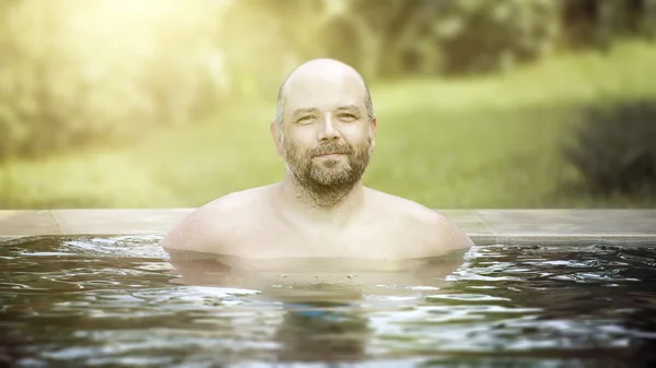 Homem relaxante na piscina exterior — Fotografia de Stock