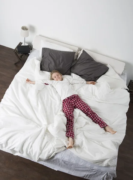 Niña en una cama grande — Foto de Stock