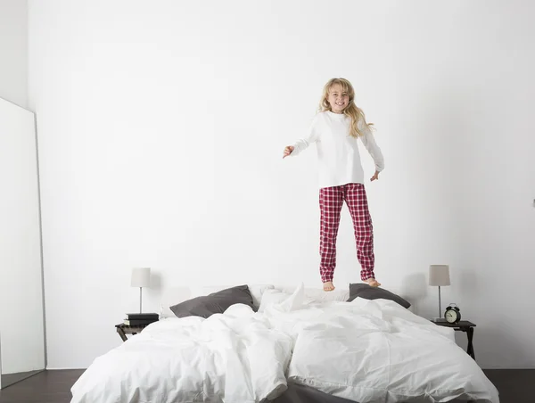 Menina feliz pulando na cama — Fotografia de Stock