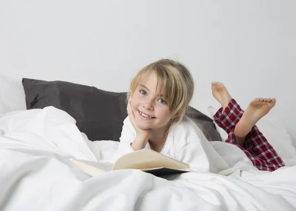Genç kız okuma bir kitap gülümseyen — Stok fotoğraf
